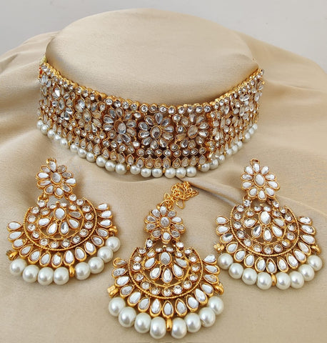 Charming Golden Color Necklace with Earrings and Matha Tikka designed with Attractive Pearls for Special Occasion