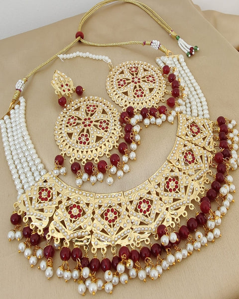Beautiful Golden Color Jadau Choker Necklace with Earrings and Matha Tikka with Charming Maroon Color Pearls for Special Occasion