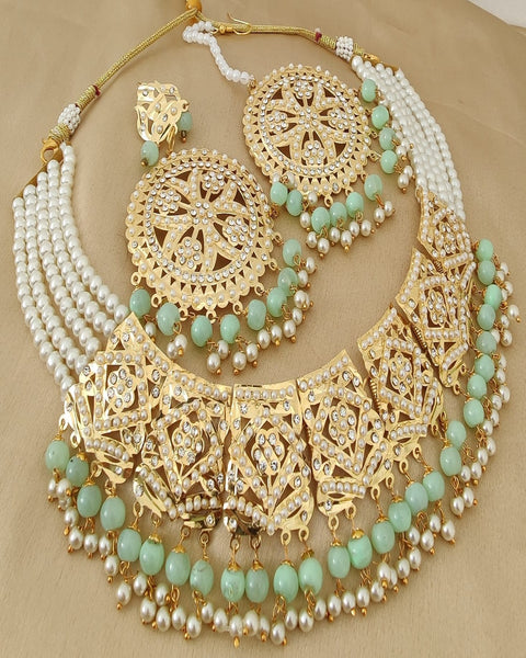 Lustrous Golden Color Jadau Choker Necklace with Earrings and Matha Tikka with Charming Light Green Color Pearls for Special Occasion